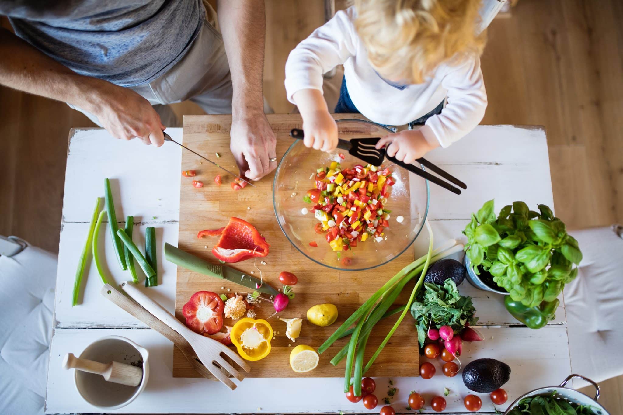 Obenansicht eines männlichen Körpers und eines Kinds beim Kochen mit Gemüse.