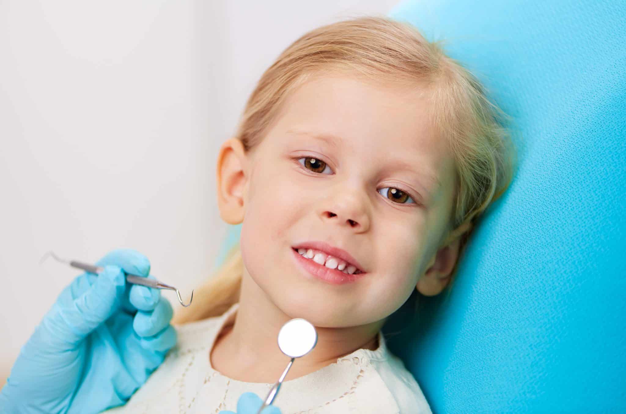 Kind mit langen Haaren beim Zahnarzt
