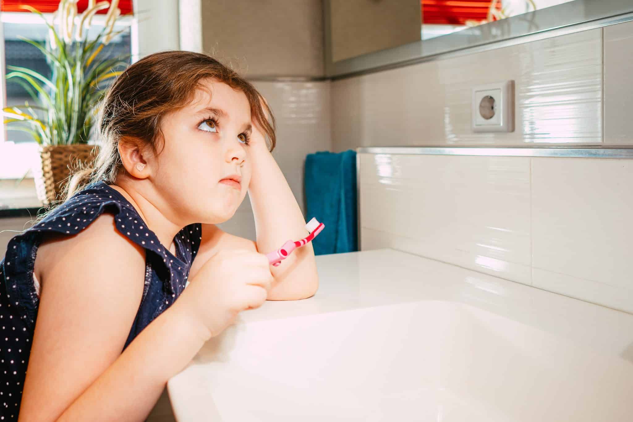 Ein kleines Mädchen im Badzimmer beim Zähneputzen.
