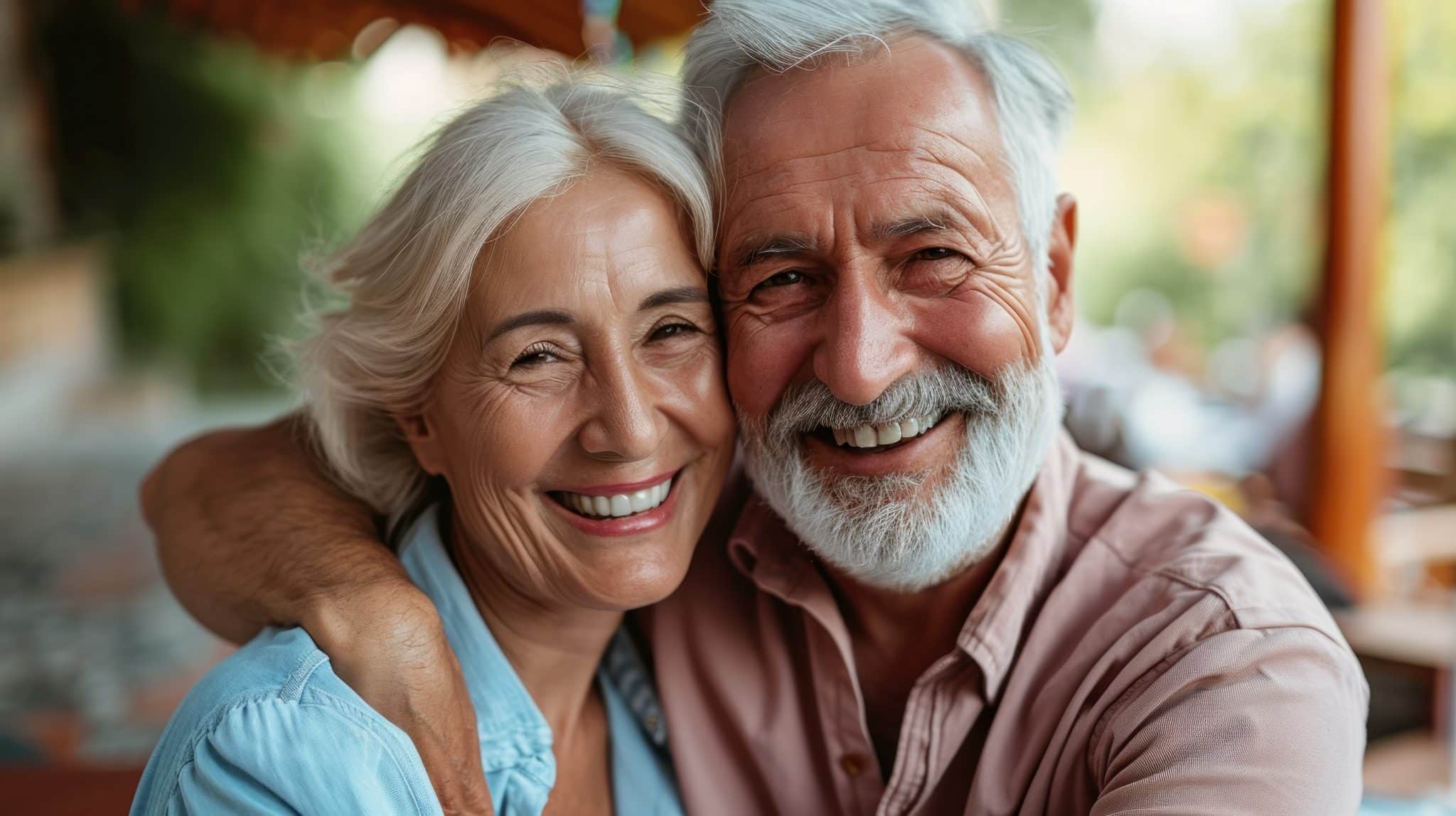 Das Foto zeigt ein glückliches, älteres Paar mit strahlendem Lachen und gesunden Zähnen.
