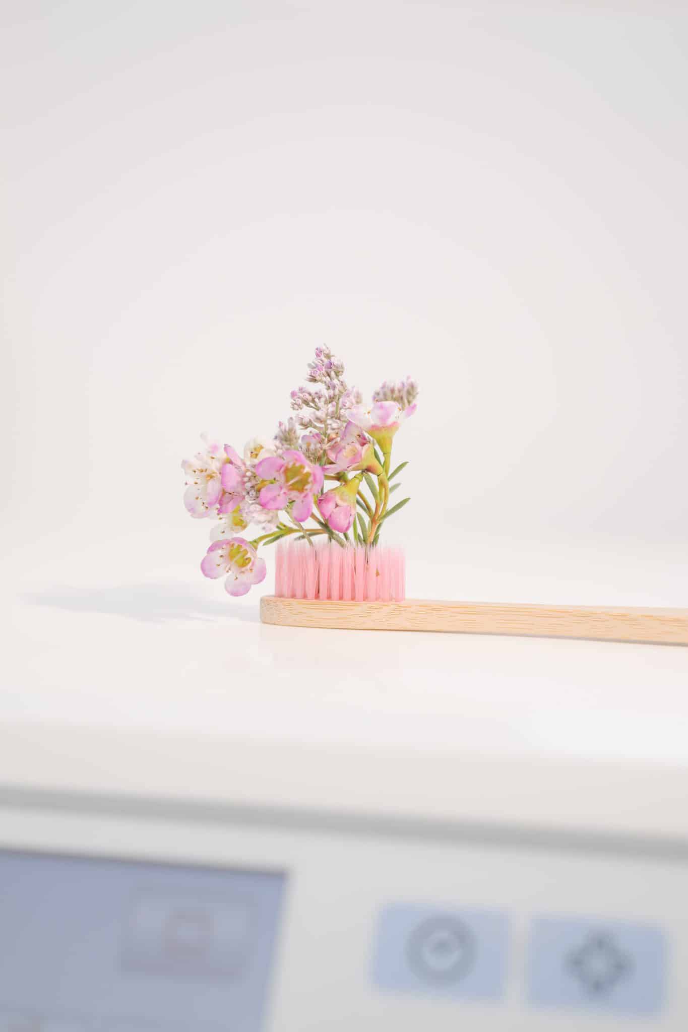 Eine mit Blümchen geschmückte, nachhaltige Holzzahnbürste ist auf dem Bild zu sehen.